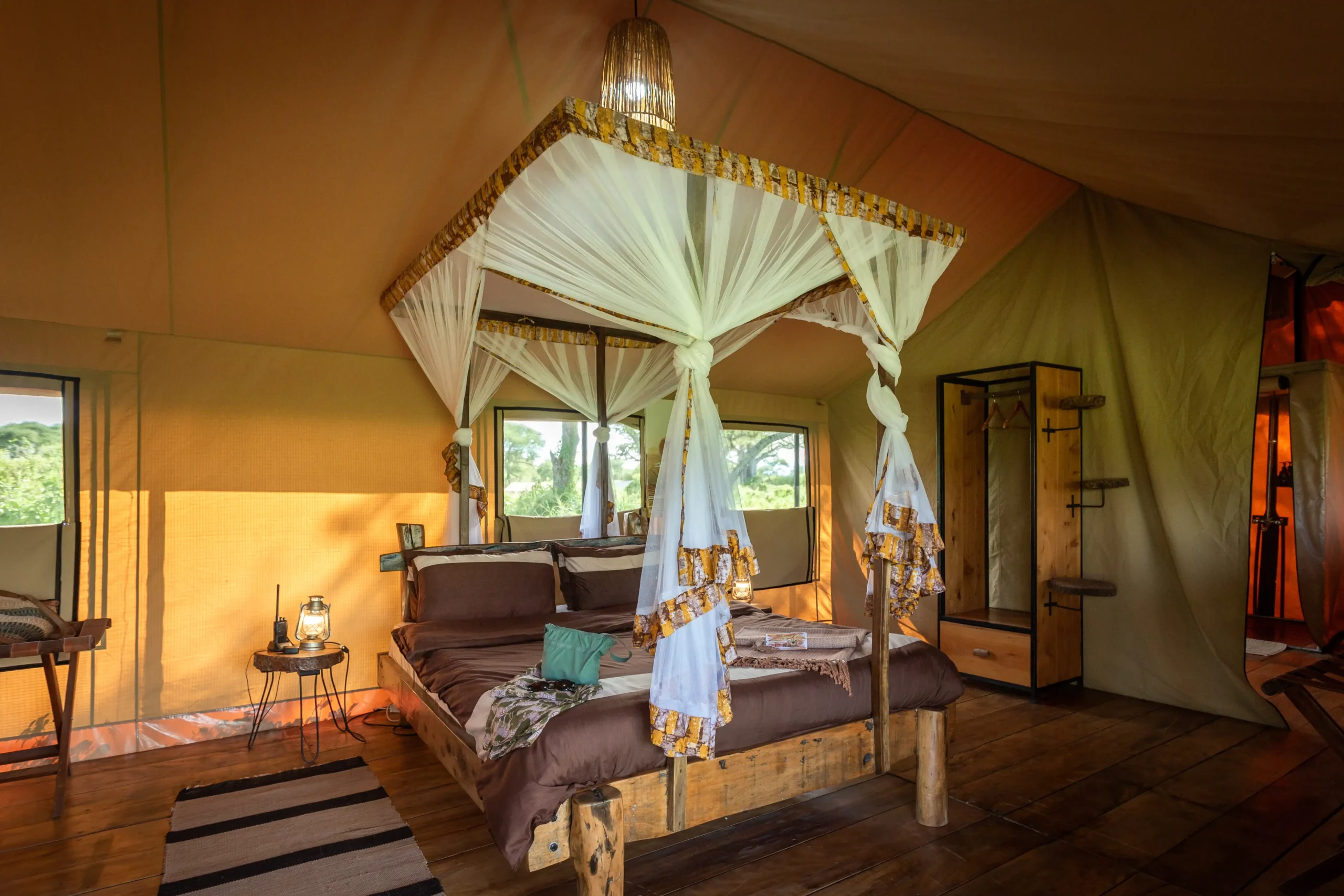 Canopy bed and mosquito net inside a Baobab Tented Camp guest tent