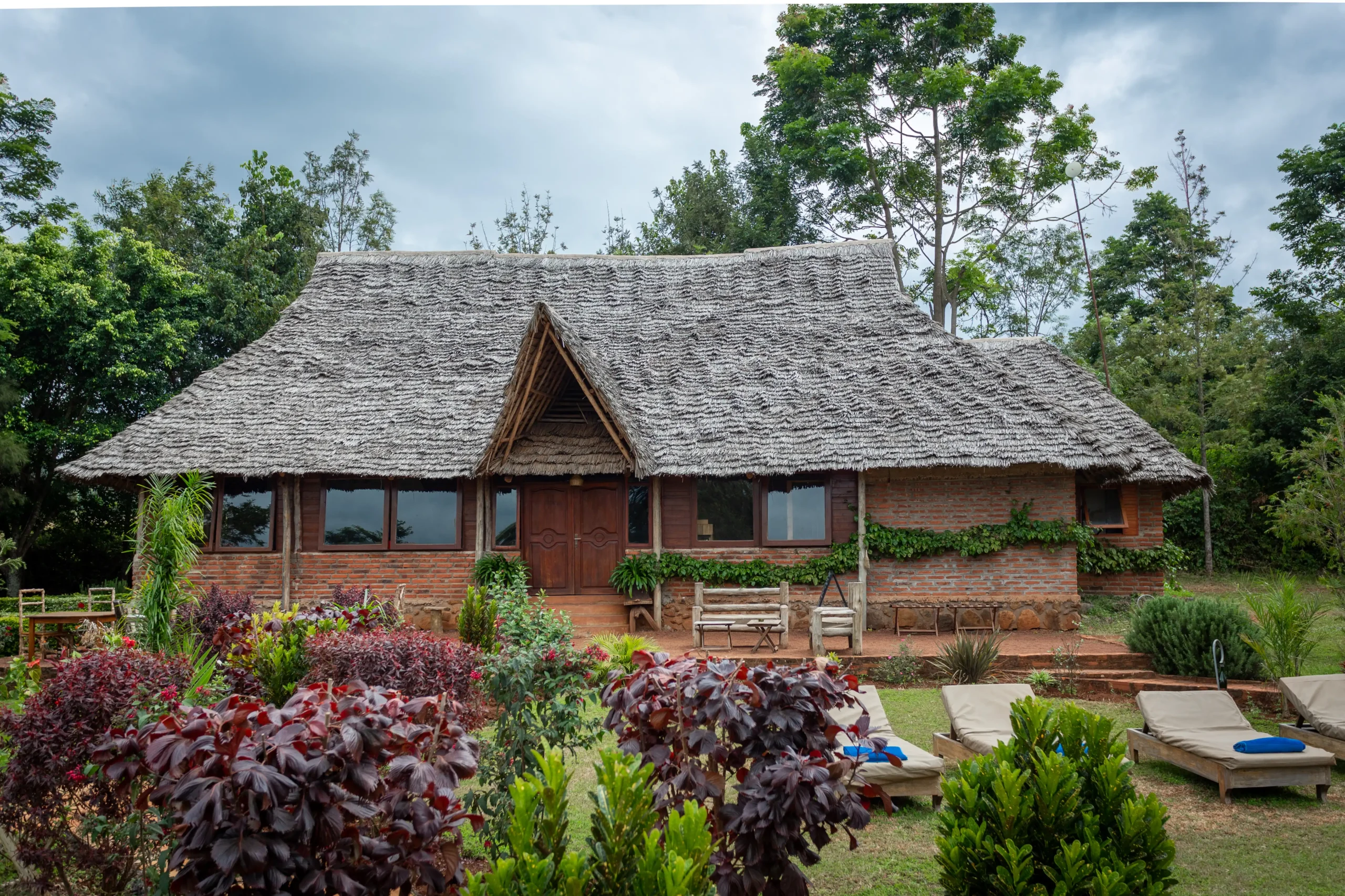 Thatched buildings and flower beds at Karatu Tented Lodge