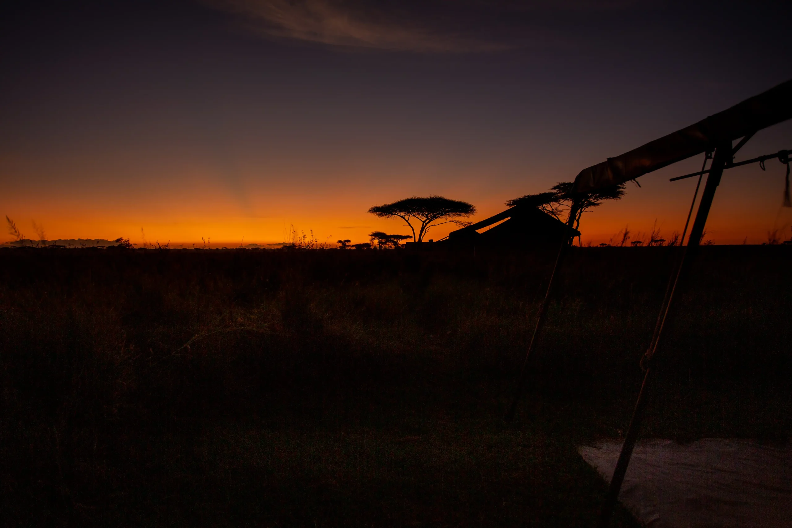 Camp silhouetted against an orange sunset