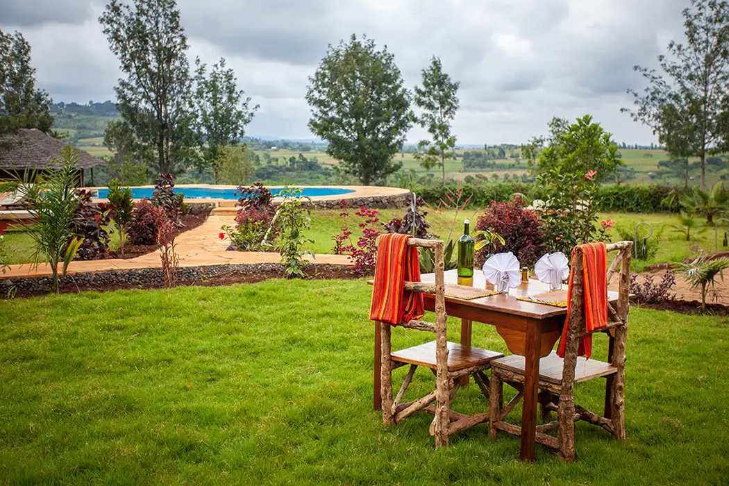 A table laid for a meal beside the pool at Karatu Tented Lodge