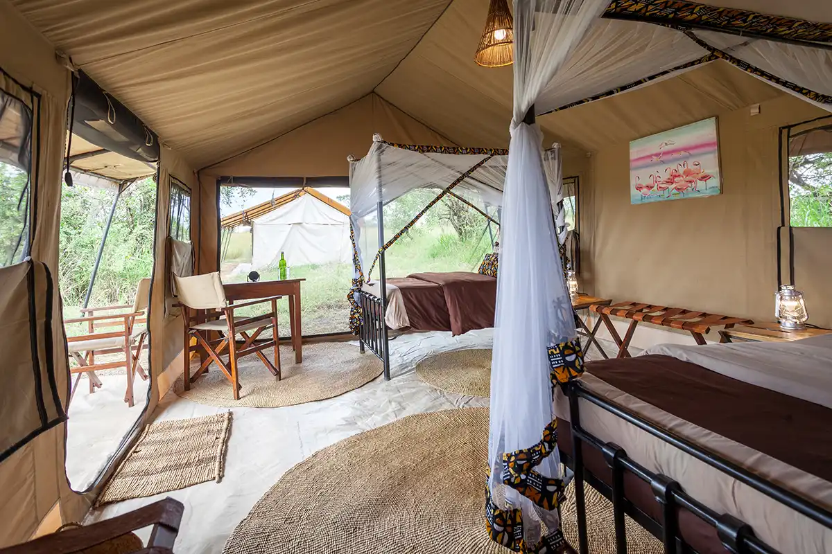 Safari tent bedroom with mosquito net and writing desk
